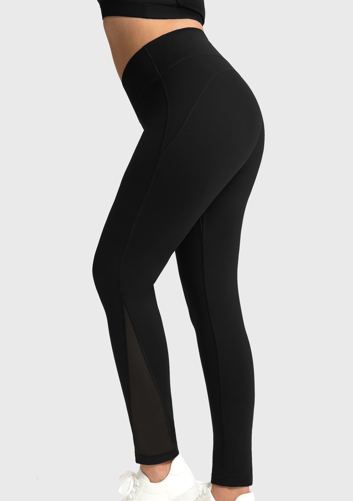 Side profile of the black athletic leggings featuring highly breathable mesh splicing on the calf for a visually slimming effect.