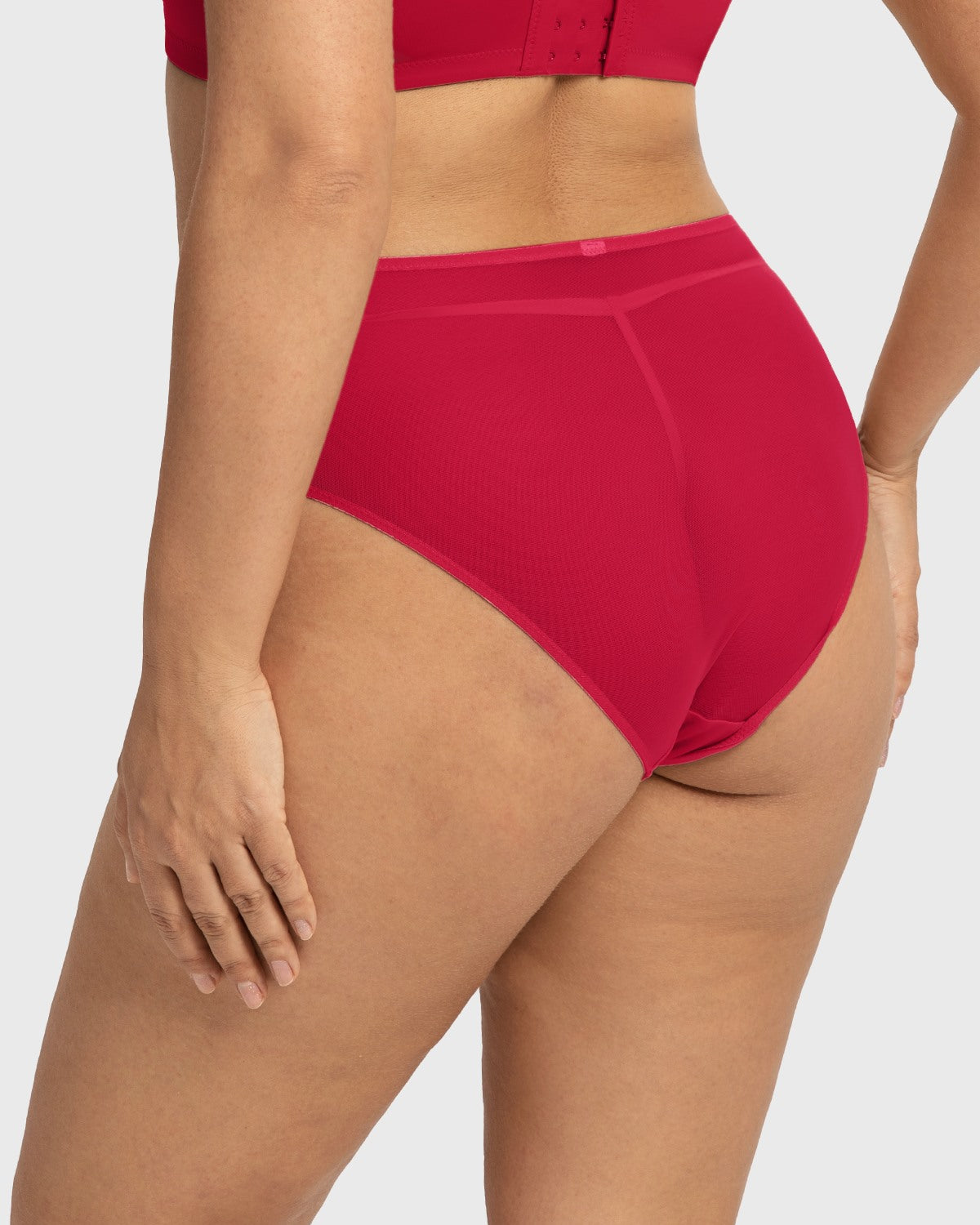 Side profile of model wearing the Coral Red Dahlia high waist underwear, showing off the flattering silhouette and premium stretchy fabrics.