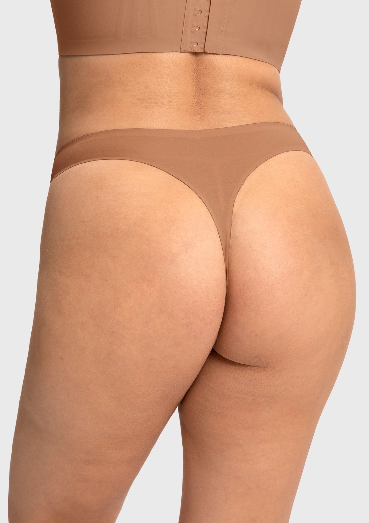 Back view of the Coffee mid-rise thong, guaranteeing a seamless look under dark fitted leggings or dresses.