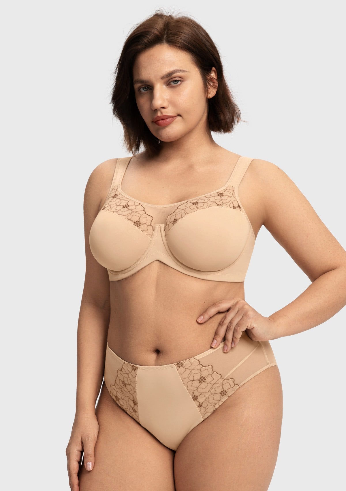 Confident woman with hands on hips wearing the light beige unlined bra for large busts, showcasing the spill-free sheer mesh neckline.