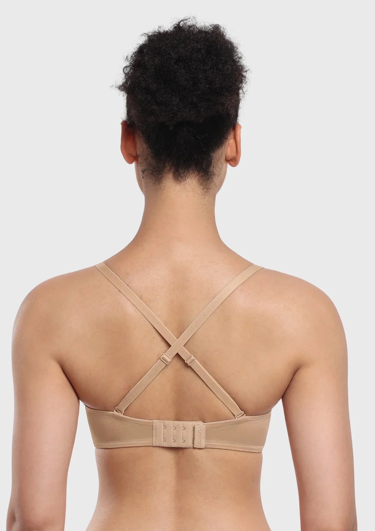 Rear view of the nude convertible bra styled with straps, showcasing the adjustable hook-and-eye closure for customized back smoothing.