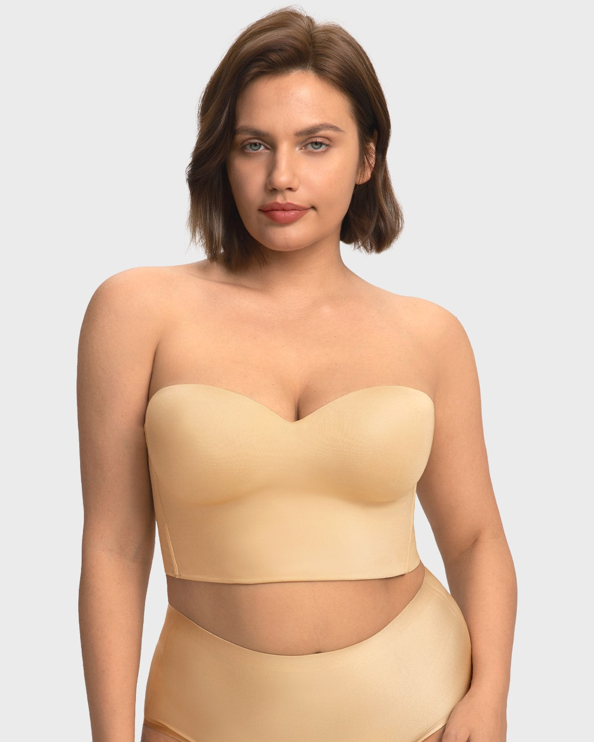 A confident woman wearing the nude supportive longline corset bra, styled effortlessly as an elegant standalone top.