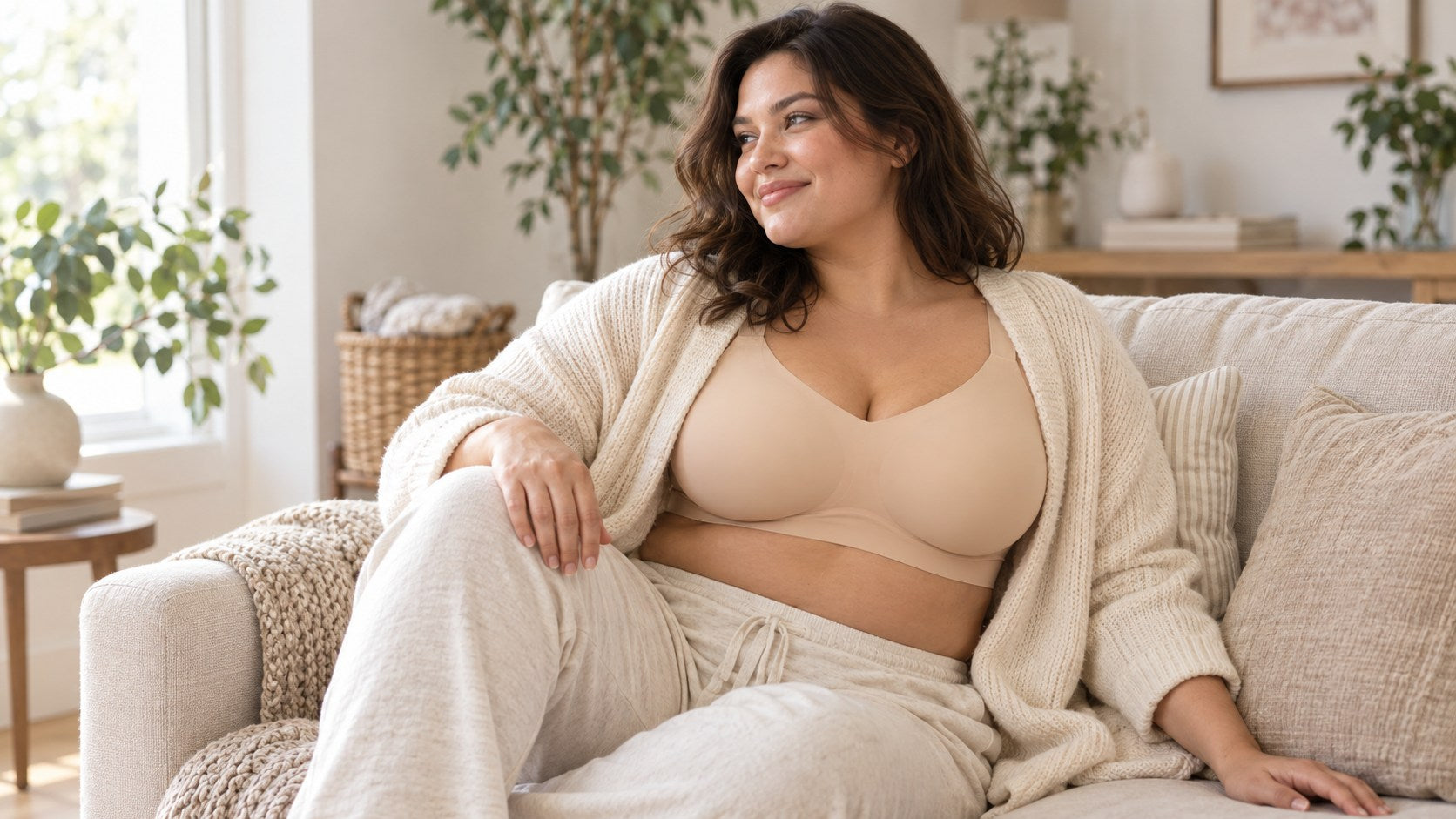 Woman relaxing on a sofa in a beige bra and cream cardigan