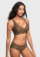 A woman modeling a leopard-print two-piece bikini set against a light gray studio background. The set features a triangle-style bra top and matching high-waisted briefs in a brown, black, and tan animal print pattern.