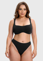 A woman modeling a black two-piece bikini set against a light gray studio background. The set includes a scoop-neck bikini top with wide straps and matching high-cut bikini bottoms.