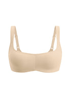 A beige wireless bralette with adjustable shoulder straps, shown against a plain white background.