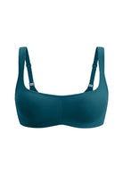 A dark teal blue-green sports bra with adjustable shoulder straps, shown against a plain white background.